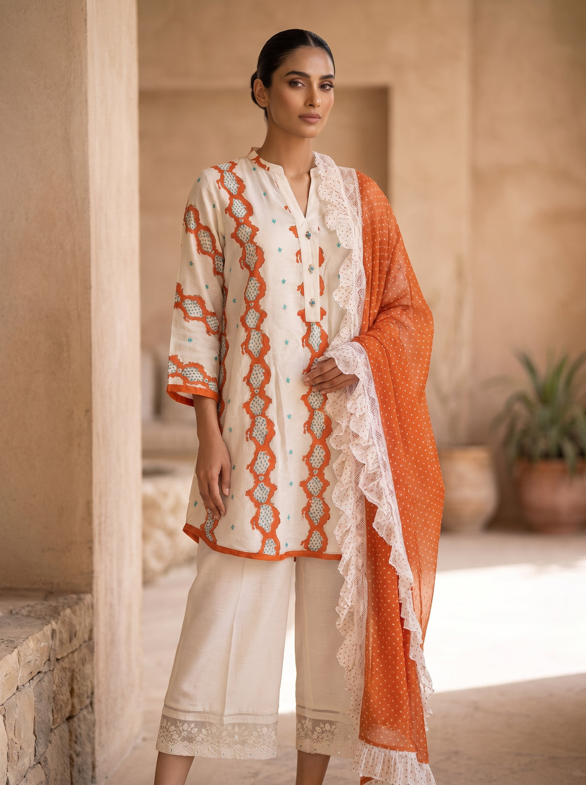 Saffron Ruffles, a three piece raw silk set with polka dot dupatta by Jannat and Sadaf